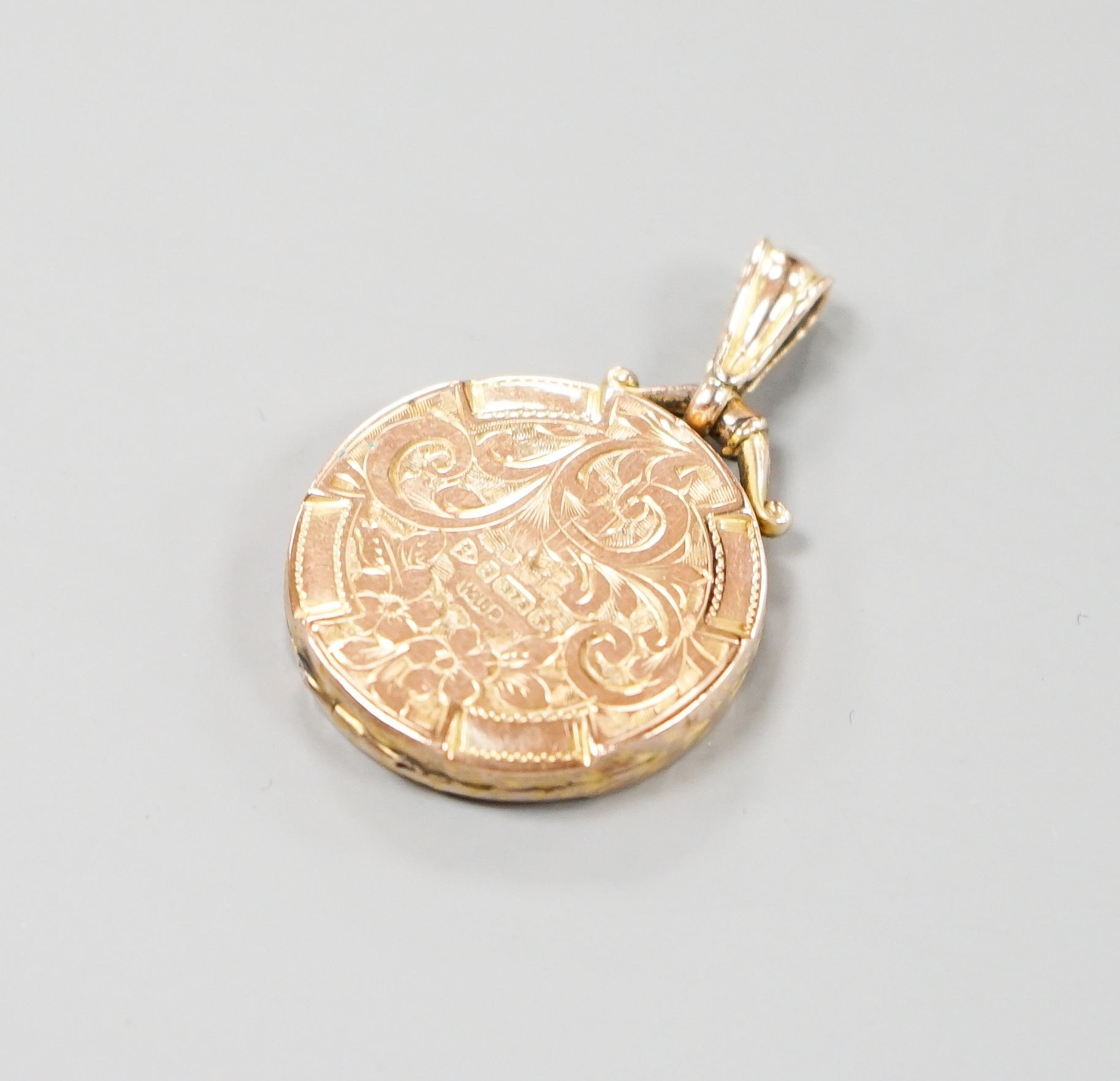 An Edwardian engraved 9ct gold circular locket, 23mm, gross weight 4.4 grams.